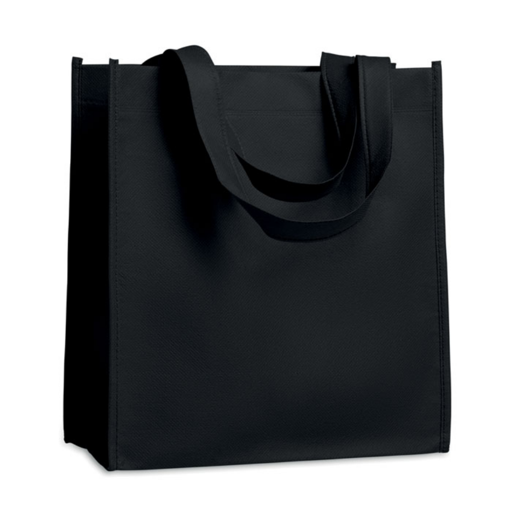 A shopping bag made from nonwoven material that has been heat sealed for durability. It comes with short handles for easy carrying. - Skipton